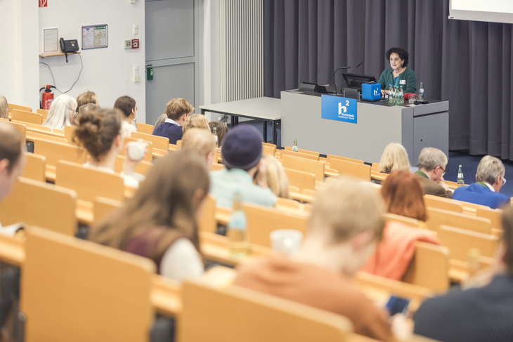 Eine Vortragende spricht in einem Hörsaal vor Publikum