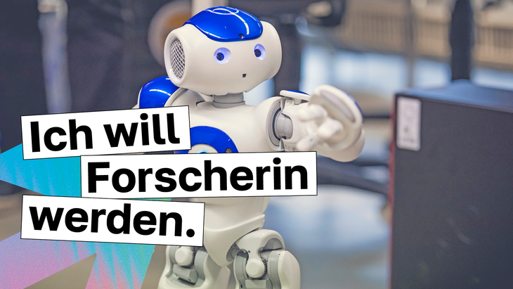 Unser Roboter "NAO" hinter dem Text "Ich will Forscherin werden."
