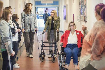 Das Bild zeigt Personen, die Rollstuhl und Rollator.
