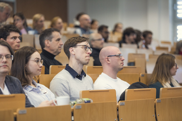 Das Bild zeigt Personen die in einem Hörsaal sitzen.